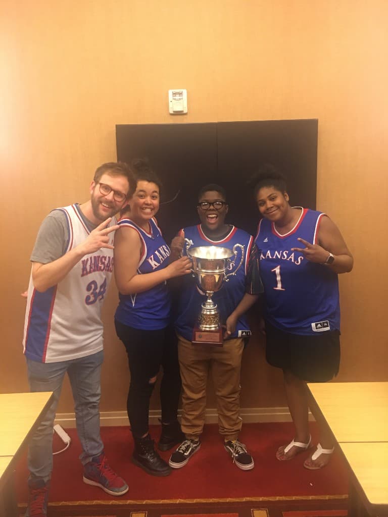 KU Debate team celebrating with a trophy